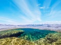 Split underwater view of clouds over a rocky sea bed in Alghero