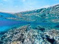Split underwater view of rocks and blue sea in Sardinia Royalty Free Stock Photo