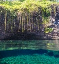 Split view of Piula Cave Pool swimming hole with clear water and Royalty Free Stock Photo