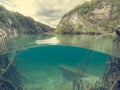 Split view of sunken boat under the lake.