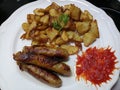 Crispy fried potatoes and pork sausages