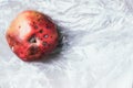 Spoiled bad red apple on plastic bag background. Garbage dump rotten food. Top view. Copy space. Rotten vegetables and fruits