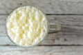 Spoiled milk. Kefir. Ayran in a glass. Glass transparent glass. Free space for text. Light gray background. Top view