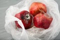 Spoiled pomegranates with mold in disposable plastic bag. Top view. Improper food storage. Concept - reduction of organic waste