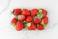 Spoiled strawberry berries with mold in transparent plastic box closeup isolated on white marble background Royalty Free Stock Photo