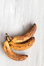 Spoiled tainted bananas on grey background. Ugly food trendy photo. Food waste, food garbage Royalty Free Stock Photo