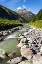 Spol River flowing in Lake Livigno, Corno Brusadella Mountain background