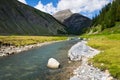 Spol River flowing in Lake Livigno, Corno Brusadella Mountain background