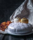 Sponge cake covered with a mirror glaze. Decorated with two white chocolate hearts. On a wooden background next to the cake are Royalty Free Stock Photo