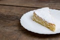 Sponge cake with cream and white chocolate decorate. Sliced piece of cake on white plate. Served on wooden table. Favorite dessert Royalty Free Stock Photo