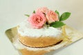 Sponge cake with icing and real pink roses