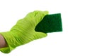 Sponge for dishes in a female hand in a green glove isolated on a white background. Copy space Royalty Free Stock Photo