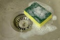 Sponge with foam in kitchen sink Royalty Free Stock Photo