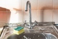 Sponge and foam solution on the kitchen sink. Cleanliness concept Royalty Free Stock Photo