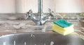 Sponge and foam solution on the kitchen sink. Cleanliness concept Royalty Free Stock Photo