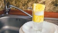 Sponge with foam for washing dishes in glass on the sink at the kitchen. Royalty Free Stock Photo