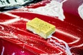 Sponge over the red car for washing. Royalty Free Stock Photo