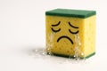 Sponge with a sad face cries soap bubbles. Space for text. Royalty Free Stock Photo