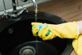 Sponge for washing dishes in hand. Blue sponge washing liquid soap on dirty sink dishes and kitchen ware Royalty Free Stock Photo