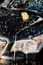 Sponge on wet and luxury black car in foam Royalty Free Stock Photo