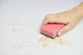 Sponge in woman hand removes dirt, bread crumbs and leftovers. Cleaning kitchen table. Household chores