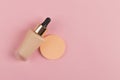 Sponges, a beautiful blender for applying foundation or powder and a bottle of concealer. Flat lay on a pink background, copy Royalty Free Stock Photo