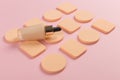 Sponges, a beautiful blender for applying foundation or powder and a bottle of concealer. Flat lay on a pink background, copy Royalty Free Stock Photo