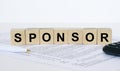 Sponsor word concept written on wooden cubes blocks