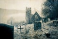 A spooky, abandoned graveyard with a ruined church in the background. With a blurred, vintage, grunge edit