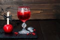 Spooky bloody cocktail and red caramel apple. Traditional dessert and drink recipe for Halloween party. Selective focus. Copy spac