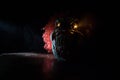 Spooky Clown head on wooden table. Evil clown head smiling on dark foggy background. Halloween concept