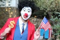 Spooky clown holding flag and dollar sign