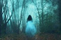 A spooky concept, of a ghostly woman in a long white dress. In a forest. On a foggy winters day.. With a grunge, textured edit Royalty Free Stock Photo