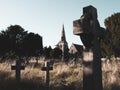 A spooky, eerie, overgrown graveyard with a church in the background. With a muted edit
