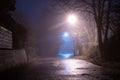 A spooky empty country road, with street lights. On an atmospheric foggy winters night. UK Royalty Free Stock Photo