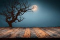 Spooky halloween night scene with old wooden table and silhouette of a dead tree Royalty Free Stock Photo
