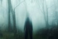 A spooky hooded figure standing in a forest. With a blurred, glitch abstract edit Royalty Free Stock Photo