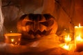 Spooky Jack o lantern carved pumpkin, spider web, candy bucket, spiders and glowing light in dark. Scary atmospheric halloween Royalty Free Stock Photo