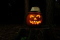 Spooky jack o lantern with hat glowing in the dark night Royalty Free Stock Photo