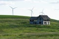 Spooky, old abandoned farm house in the rolling hills of The Palouse in Washington State. Windmills in background Royalty Free Stock Photo