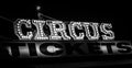 Spooky old dimly lit circus sign with light bulbs in the dark over a ticket stand in black and white. Typical view of an entrance Royalty Free Stock Photo