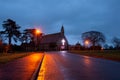 A spooky old Victorian church with a glowing cross on a winters night