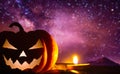 Spooky pumpkin head jack o& x27; lantern glowing with a burning candle in the night sky. Halloween background Royalty Free Stock Photo