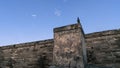 Spooky scene with a bird standing on a old historic fort wall.