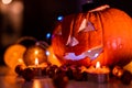 Spooky smiling halloween pumpkin in burning fire candles flames.