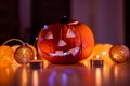 Spooky smiling halloween pumpkin in burning fire candles flames.