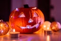 Spooky smiling halloween pumpkin in burning fire candles flames.