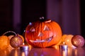 Spooky smiling halloween pumpkin in burning fire candles flames.