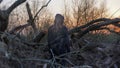 A spooky, transparent ghost figure watching the sunset. On an eerie winters day in the countryside. With a grunge, blurred vintage