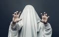 Spooky white ghost costume with black eyes on a gray background. Halloween horror minimal concept
